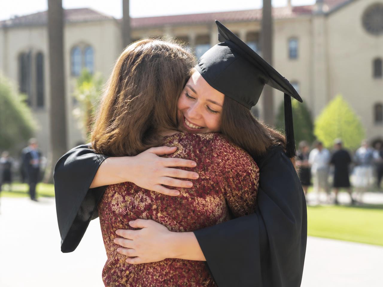 Cartoon graduate character in a cap and gown celebrating